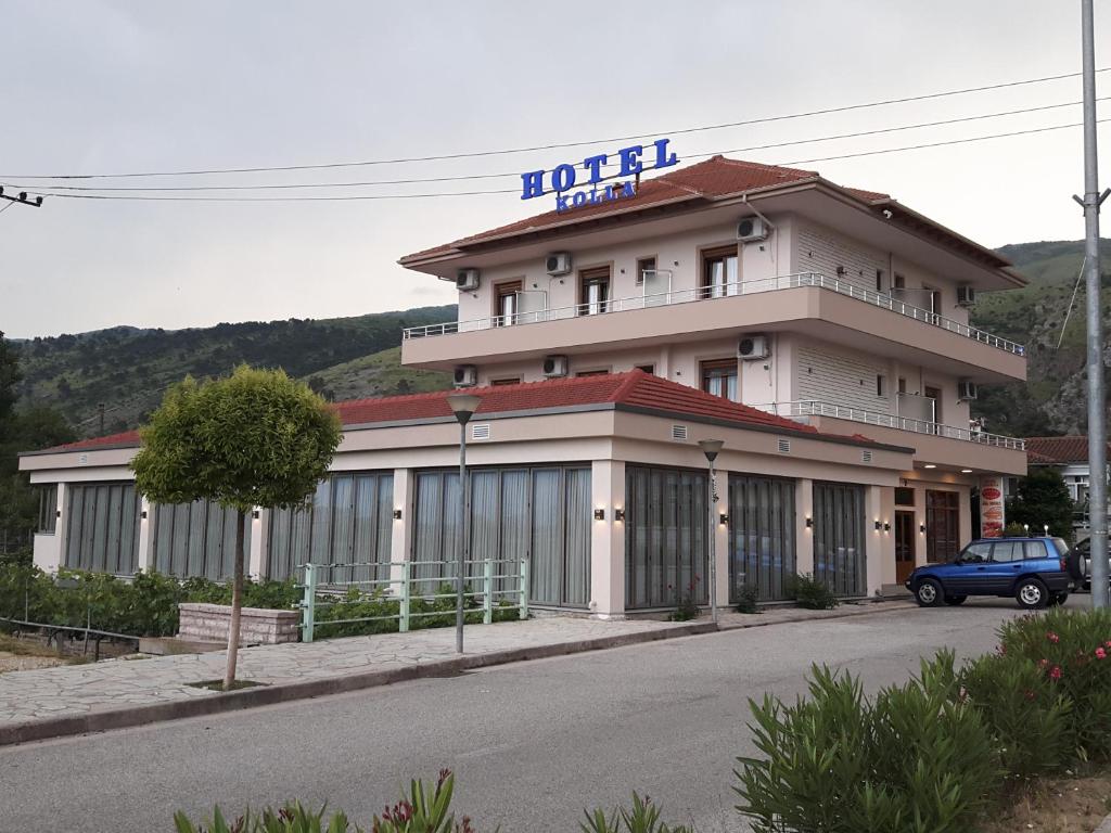 a hotel building with a car parked in front of it at Hotel Kolla in Derviçian