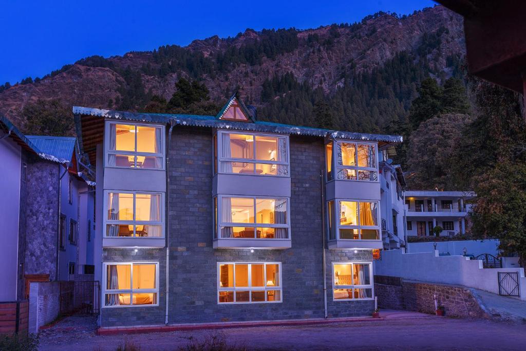 a large brick building with its lights on at The Pinewood, Nainital by Leisure Hotels in Nainital