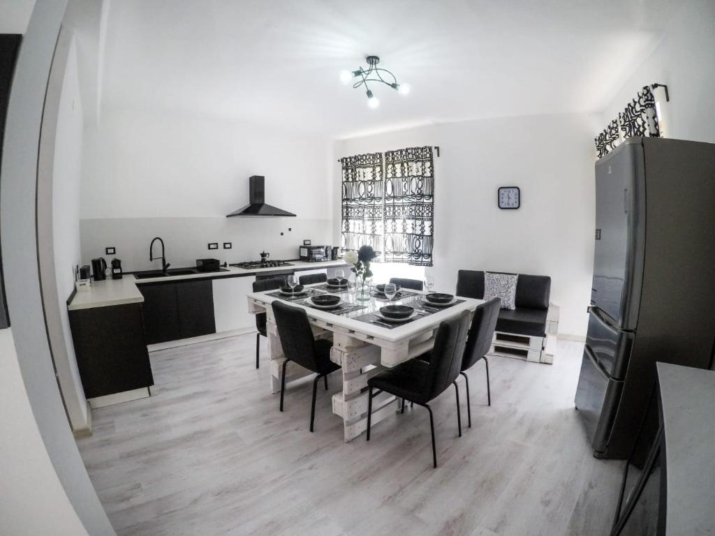 a kitchen and dining room with a table and chairs at Black&White guest house in Iglesias