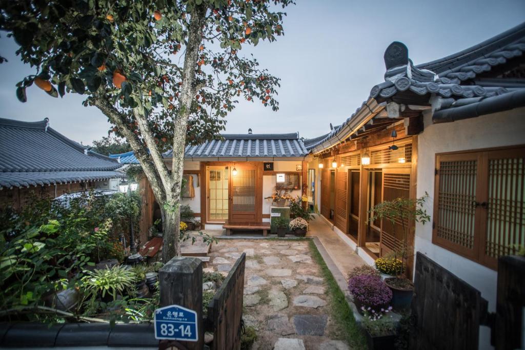 Hanok Story Guesthouse في جيونجو: منزل به مسار يؤدي إلى الفناء الأمامي