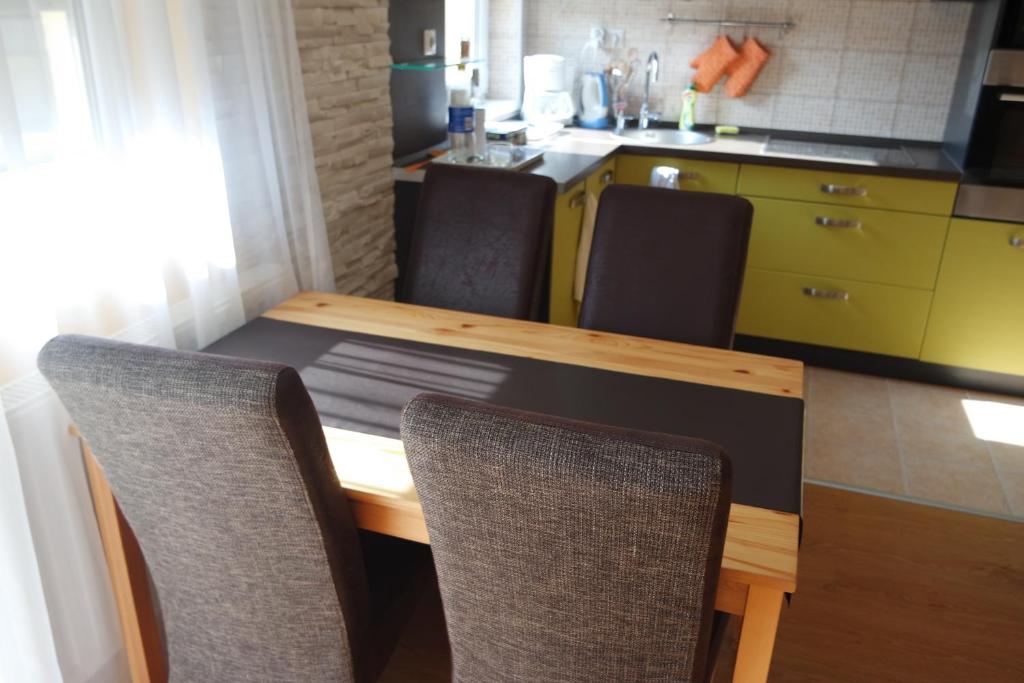 ペーチにあるÁrnyas apartmanのキッチン(テーブル、椅子付)