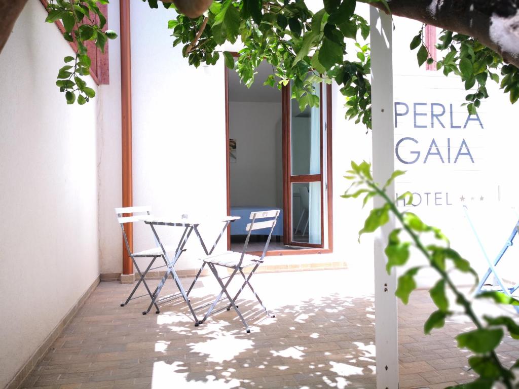 a table and chairs on the porch of a building at Hotel Perla Gaia in San Vito lo Capo