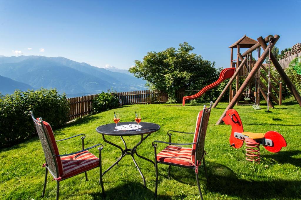 a table and chairs in a yard with a playground at Pension Wiesenrain in Maranza