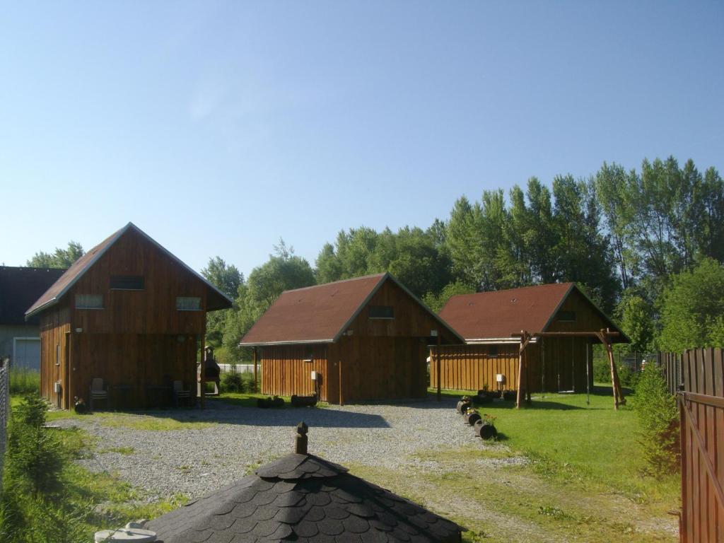 un grupo de tres graneros con pollos en el patio en Chaty Dagmar en Liptovský Mikuláš