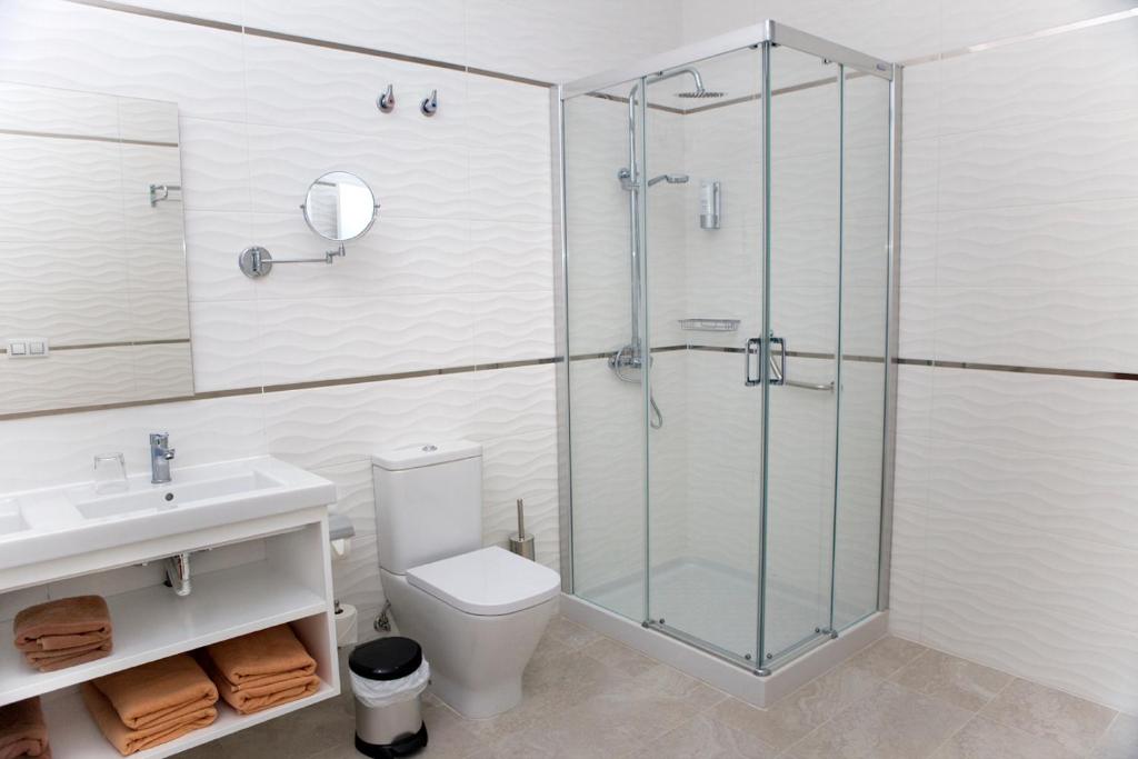 a bathroom with a shower and a toilet and a sink at Holiday Club Jardin Amadores in Amadores