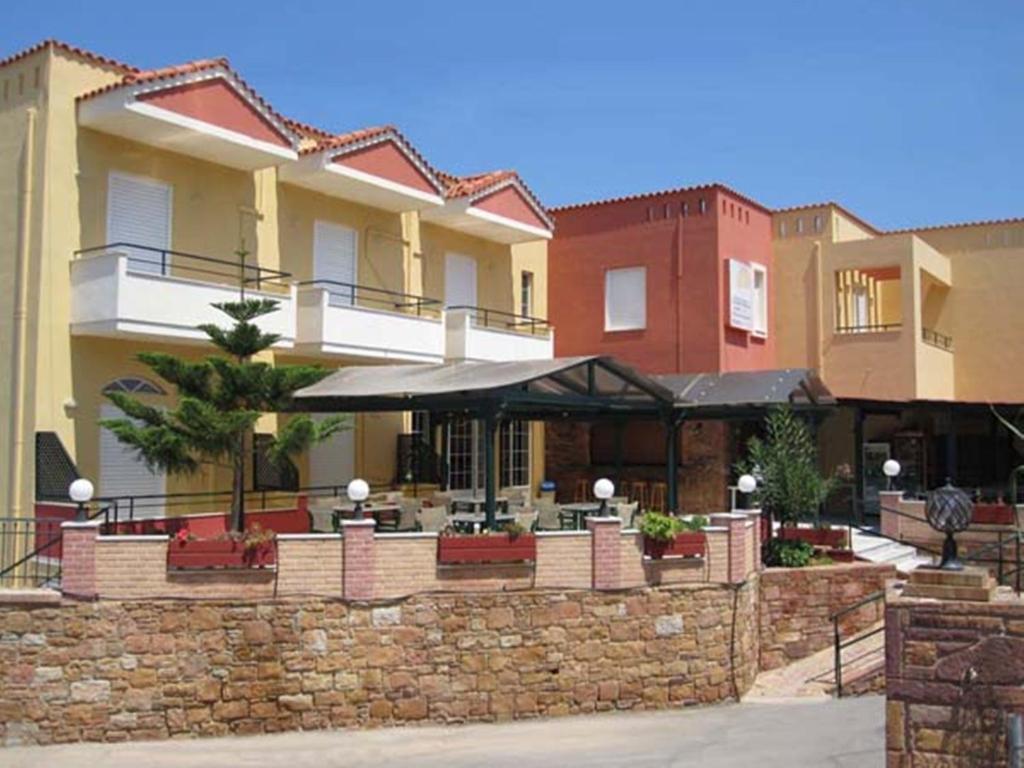 a building with a stone wall with an outdoor patio at Sunrise Hotel in Agia Ermioni