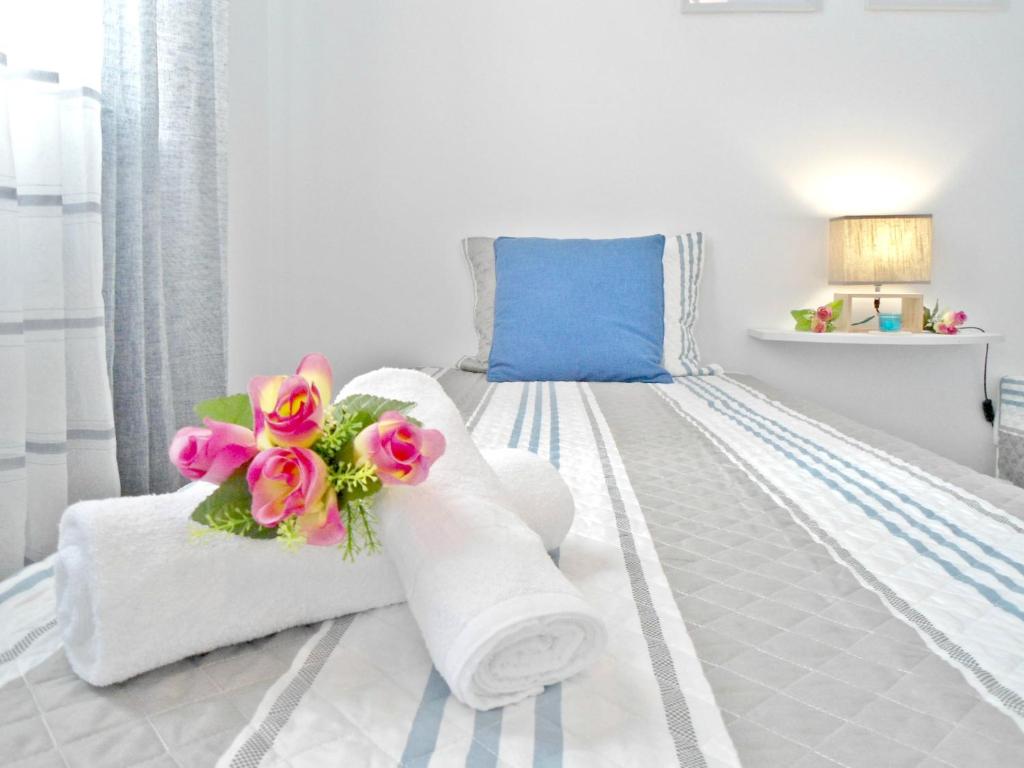 フンシャルにあるFunchal Apartmentの白いベッドルーム(タオル、花付)