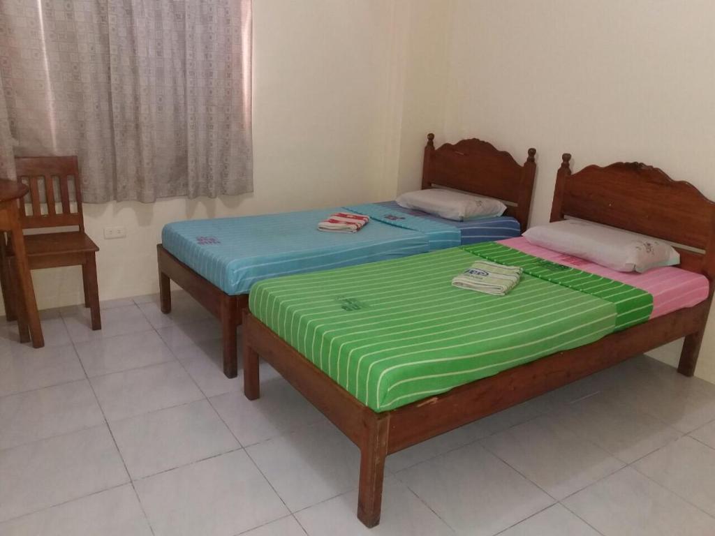 two twin beds in a room with a window at Eco Pension in Surigao