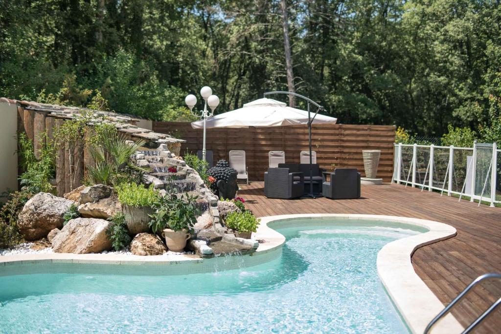 a swimming pool in a backyard with a wooden deck at Mas Des Sentes in Nans-les-Pins