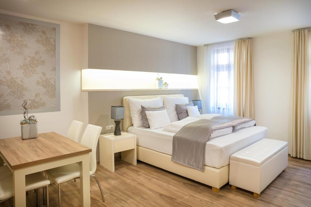 1 dormitorio con cama, mesa y escritorio en Főtér Rezidencia en Győr