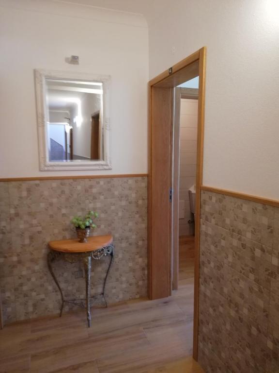 a room with a small table and a mirror at Sol Mar in Odeceixe
