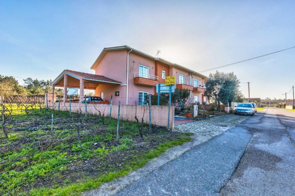 a pink house with cars parked in front of it at Casa Nana in Cadima