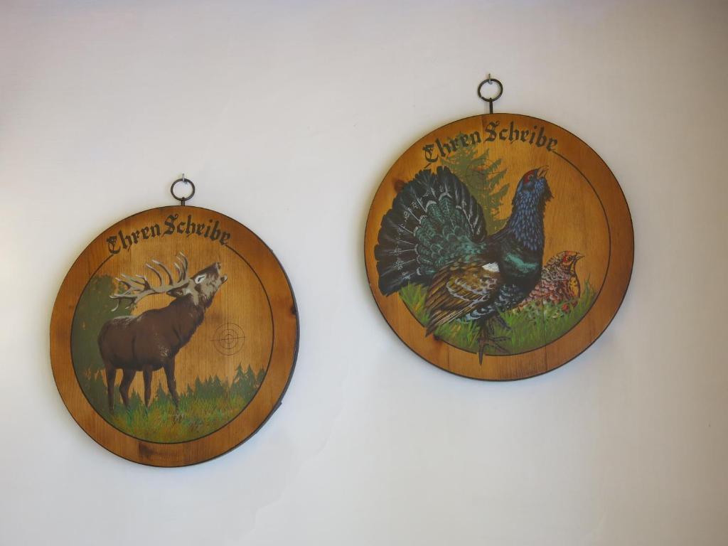 two wooden plates with a picture of a turkey and a horse at Digonera Historic Hotel B&B in Rocca Pietore