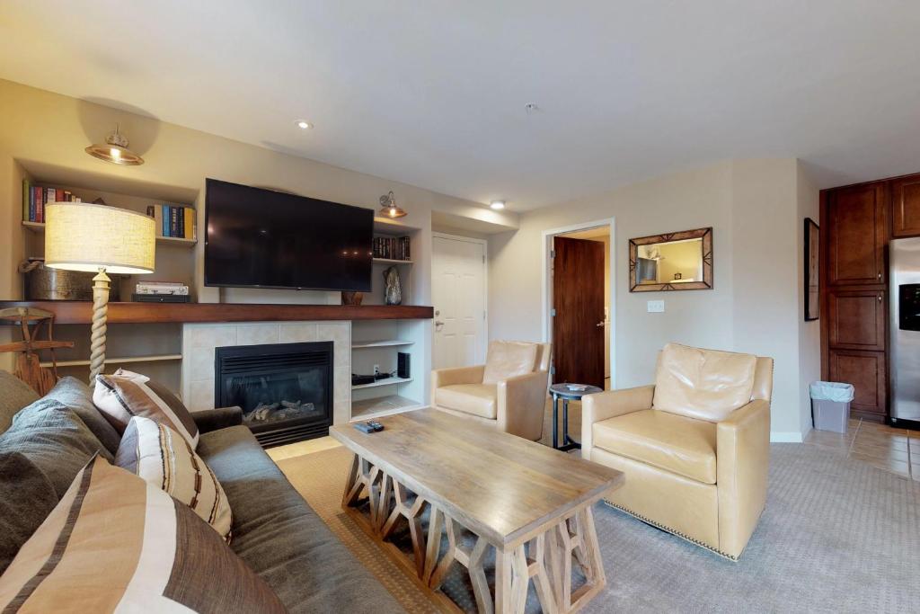 a living room with a couch and a fireplace at Sun Ray Ski Chalet in Steamboat Springs