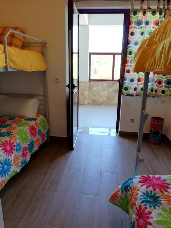 a room with two bunk beds and a sliding glass door at Sol Mar in Odeceixe