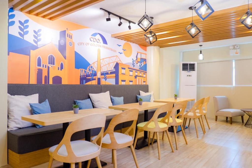 un restaurante con mesas y sillas y un mural en Bridge Hotel en Cagayán de Oro