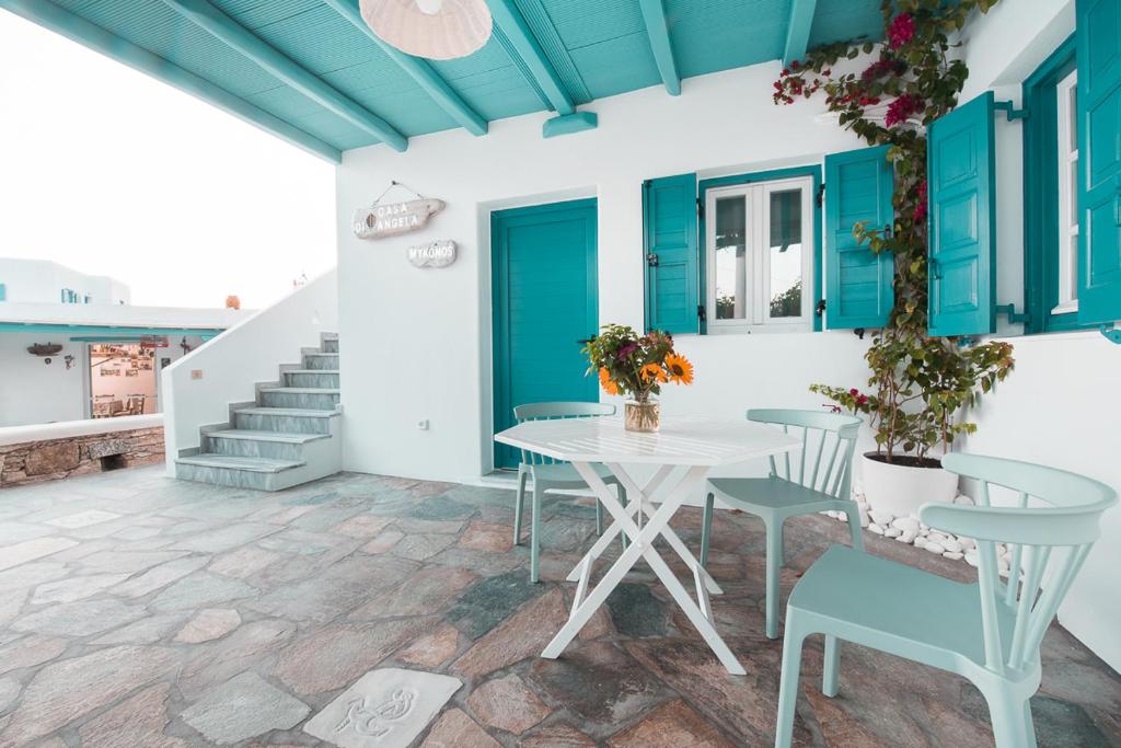 een patio met een tafel, stoelen en een trap bij Casa di Angela in Mykonos-stad