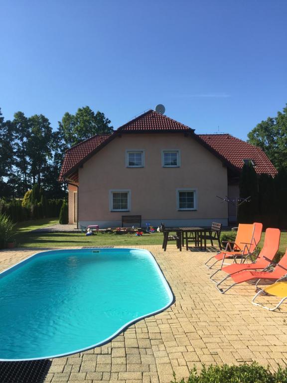uma casa com uma piscina e cadeiras e uma mesa em Ubytování Mája em Třeboň