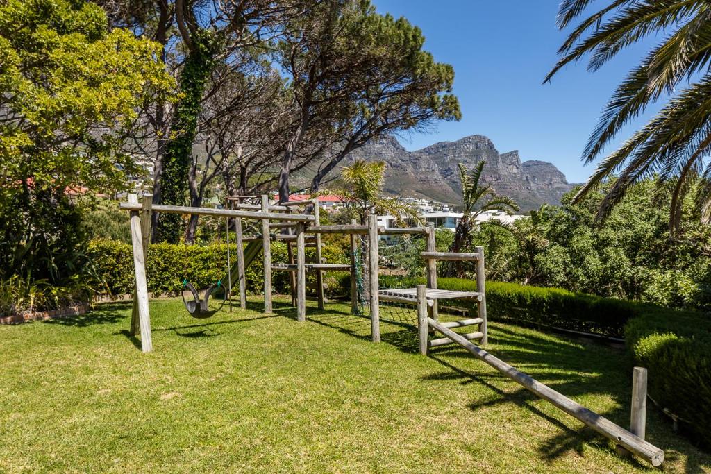 a wooden bench in the grass with mountains in the background at 42 On Strathmore in Cape Town