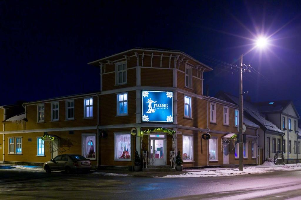 a building with a sign on the side of it at night at Villa Eeden in Pärnu