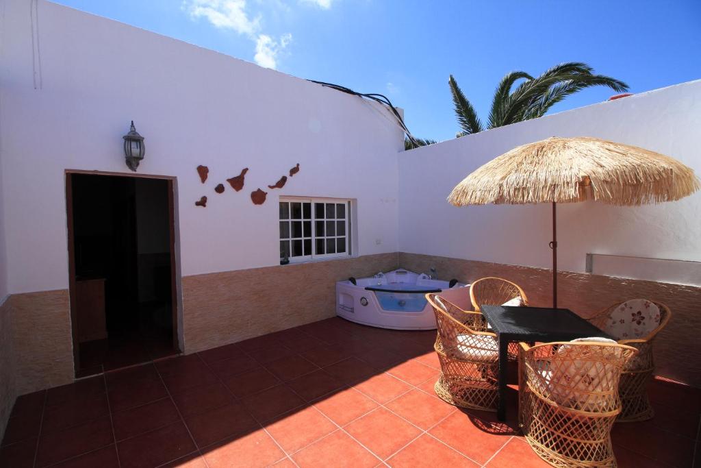 un patio con mesa, sillas y sombrilla en MONTAÑA VALLES DE ORTEGA -D, en Antigua