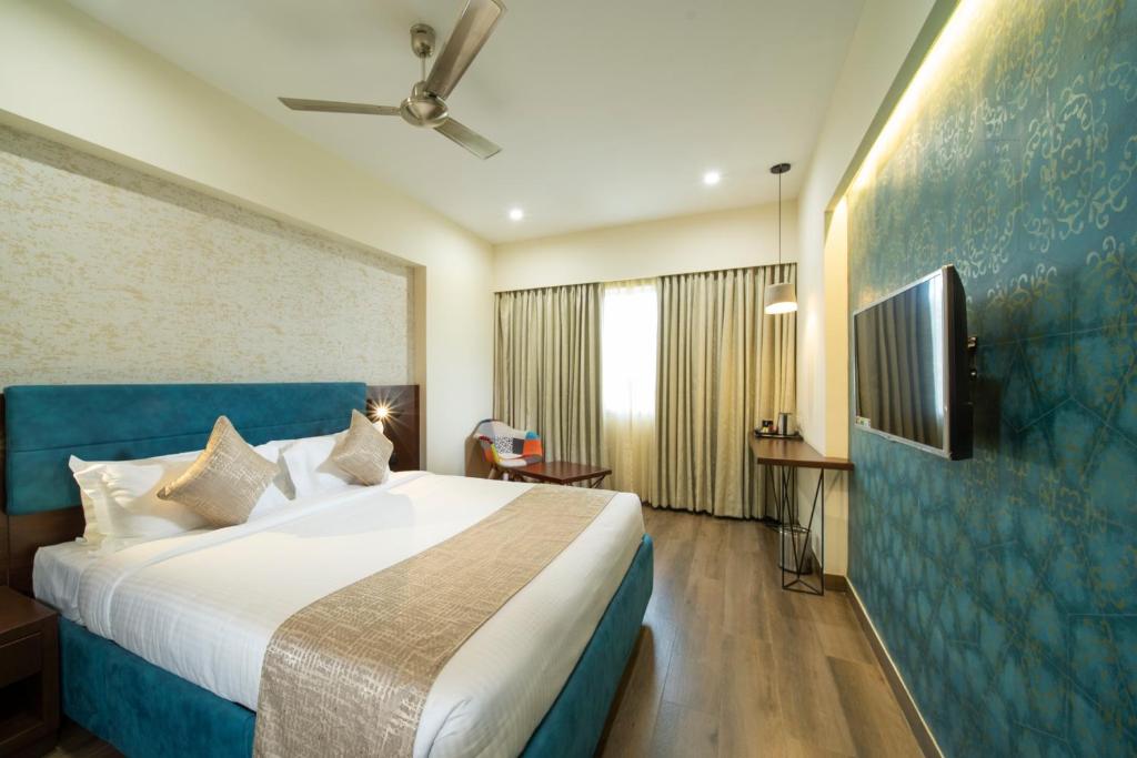 a hotel room with a bed and a flat screen tv at ICON Boutique by Bhagini in Bangalore