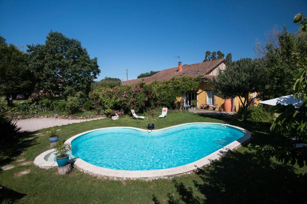 a swimming pool in the yard of a house at Domaine à Marmande in Berdoues