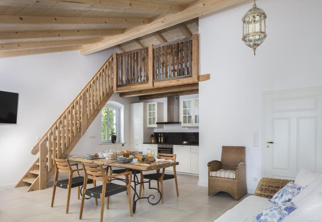 a kitchen and dining room with a table and a staircase at Ferienwohnung Chiemsee in Breitbrunn am Chiemsee