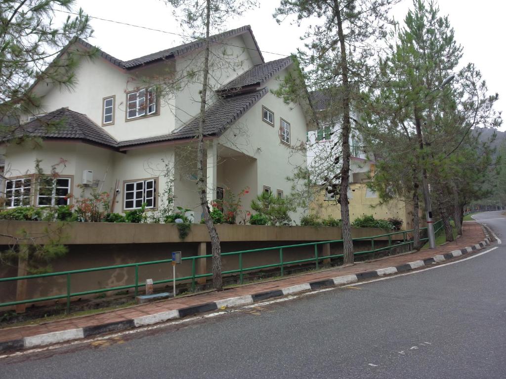 a white house on the side of a road at Cameron Highlands Muslim Apartment by AziziCameron in Cameron Highlands