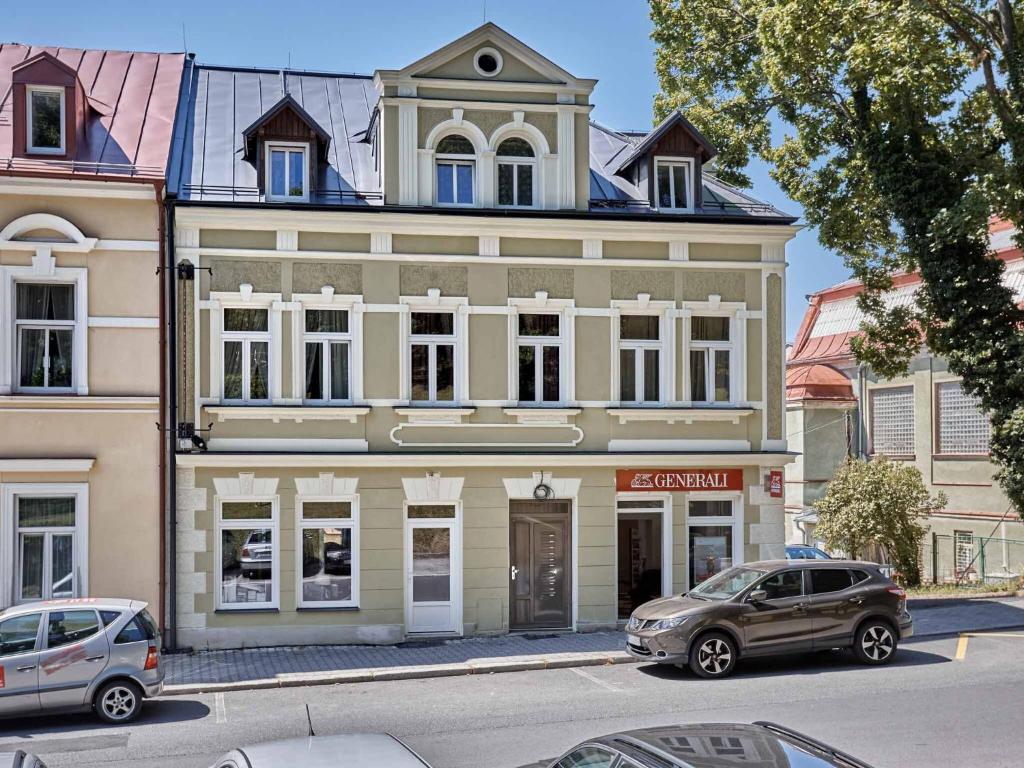 ein großes Gebäude mit davor geparkt in der Unterkunft Apart House Plesia in Marienbad