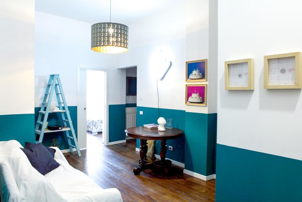 uma sala de estar com paredes azuis e brancas e uma mesa em 90100 em Palermo