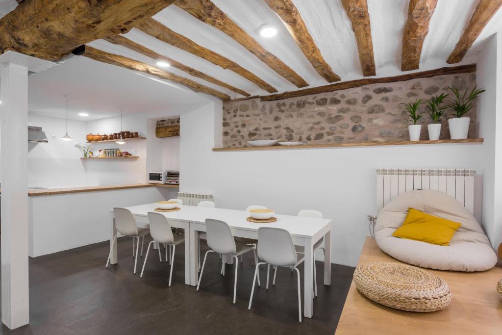 a kitchen and dining room with a white table and chairs at Hostel.B in Belorado