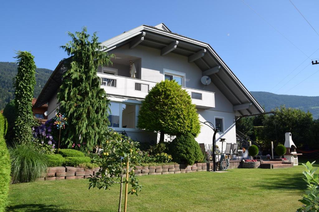 una casa blanca con un árbol en el patio en Ferienwohnung Trauntschnig en Bodensdorf