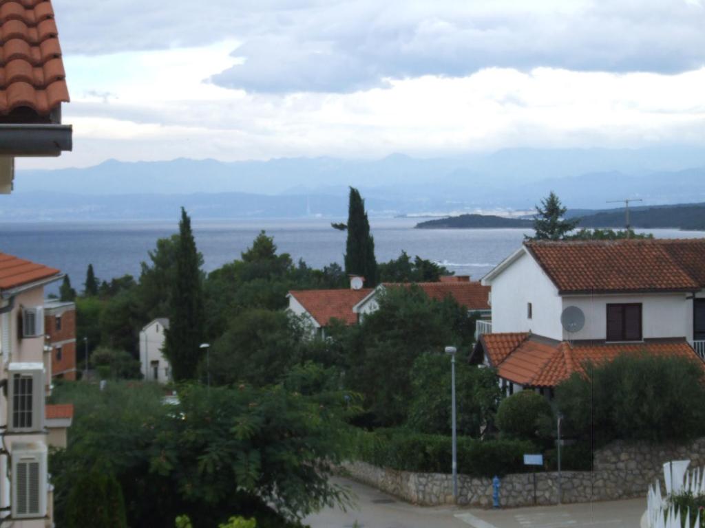 Une ville avec des maisons et l'océan en arrière-plan dans l'établissement Apartman Helen, à Malinska