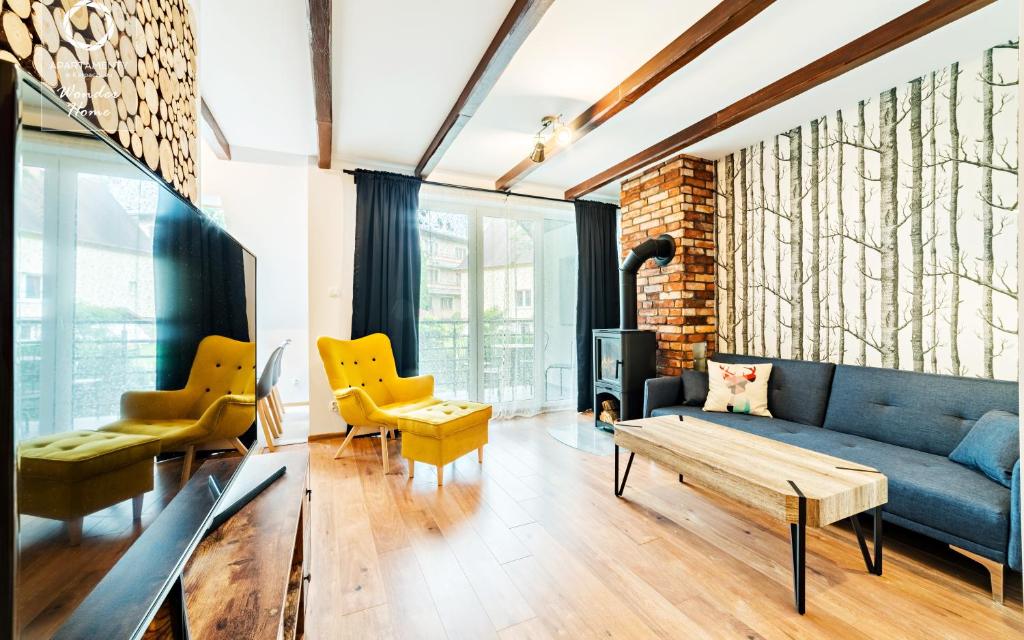 Una sala de estar con un sofá azul y sillas amarillas. en Wonder Home - Domki górskie na kameralnym osiedlu Karkonoska Opoka, en Karpacz