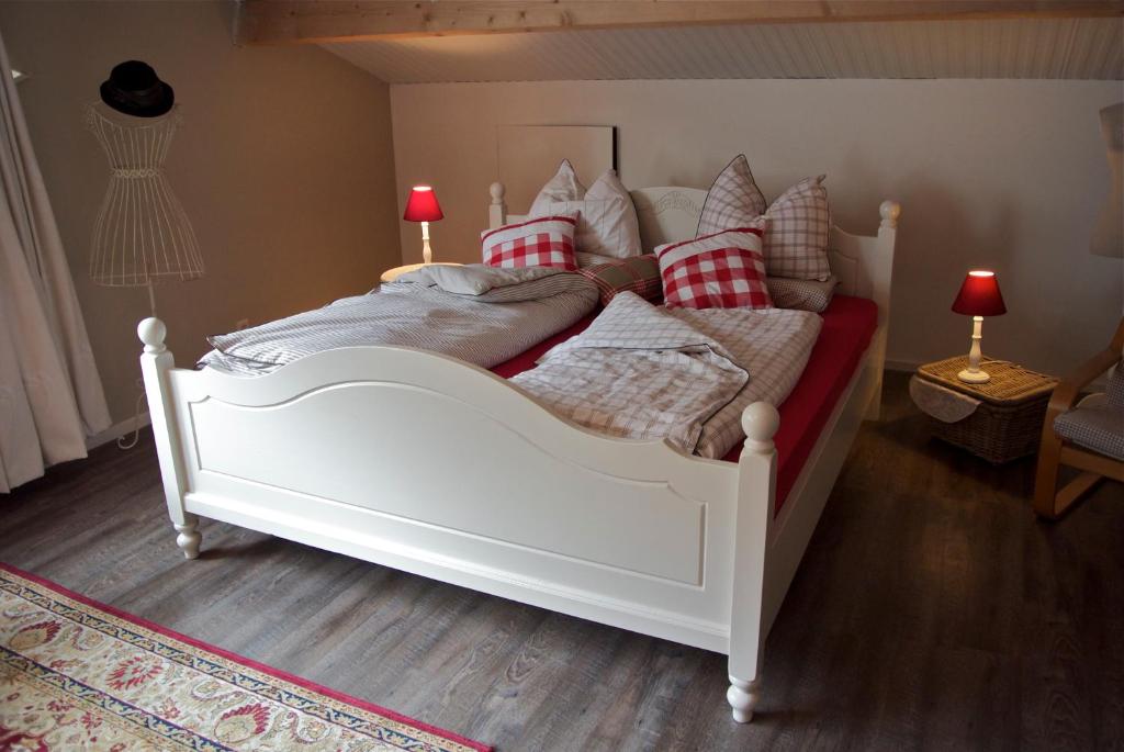 a bedroom with a white bed with red pillows at de Huttert Opkamer in Luttenberg