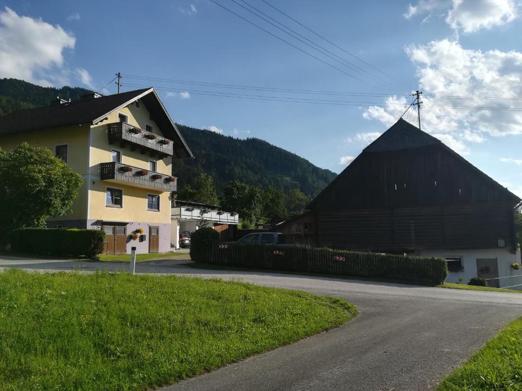 a house and a barn on the side of a road at Haus Elisabeth in Aigen im Ennstal