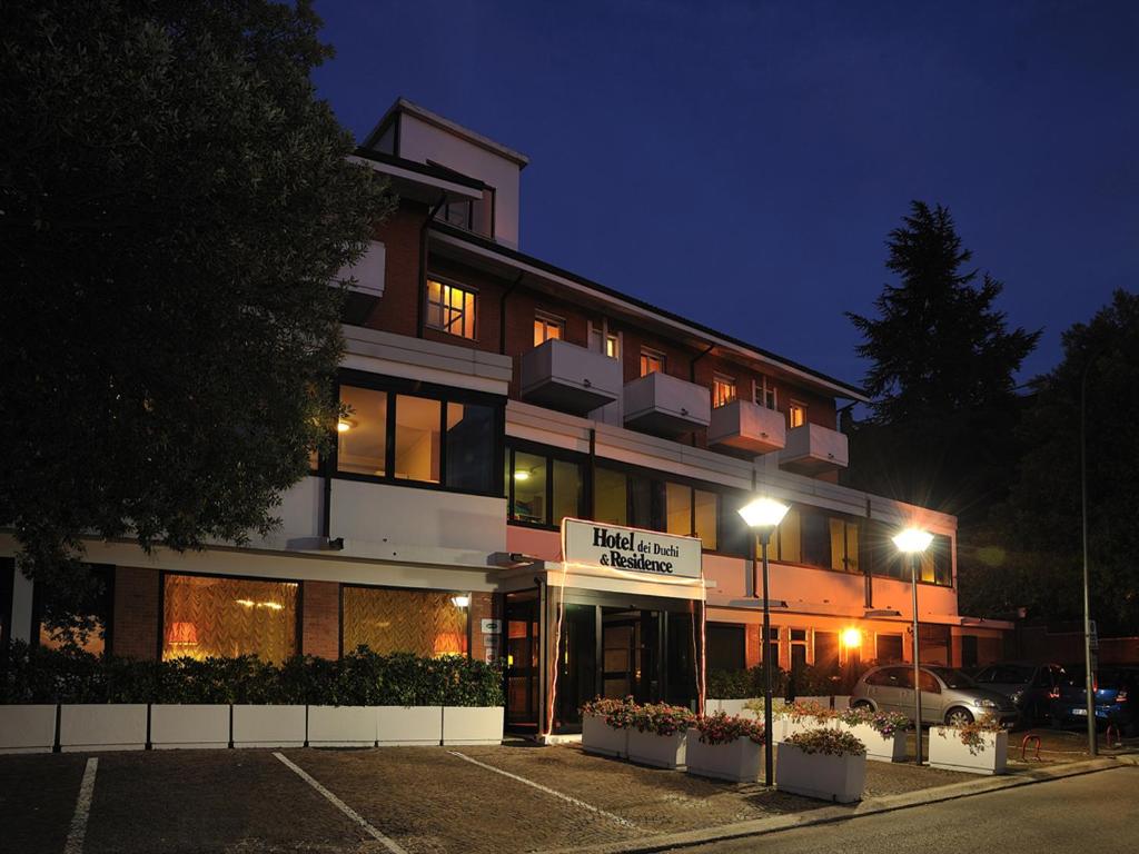 a building with a parking lot in front of it at Hotel & Residence Dei Duchi in Urbino