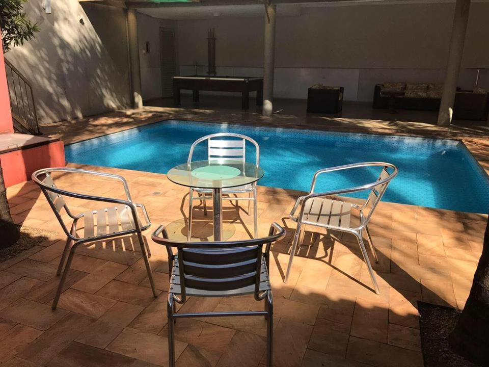 een tafel en stoelen naast een zwembad bij Ibiti Park Hotel in Ibitinga
