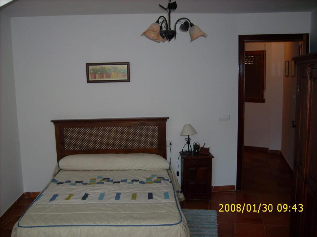 a bedroom with a bed and a lamp and a door at El Corral Del Tio Emilio in Cuenca