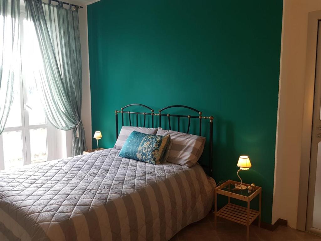 una camera con letto e parete verde di Domus lungo ticino a Pavia