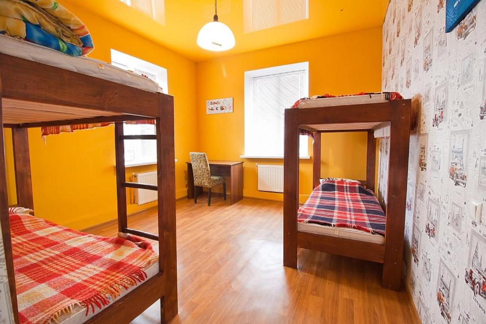 two bunk beds in a room with yellow walls at Tsentr Hostel in Vinnytsya