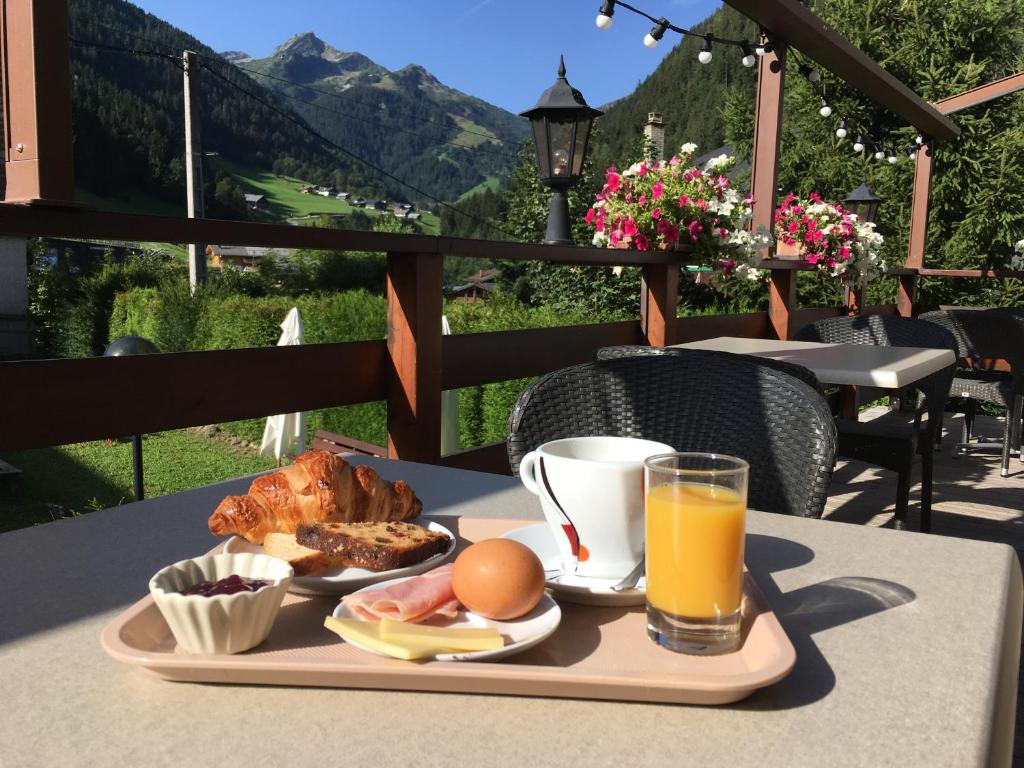 uma bandeja de comida de pequeno-almoço numa mesa com vista em Hôtel le Christiania em Arêches