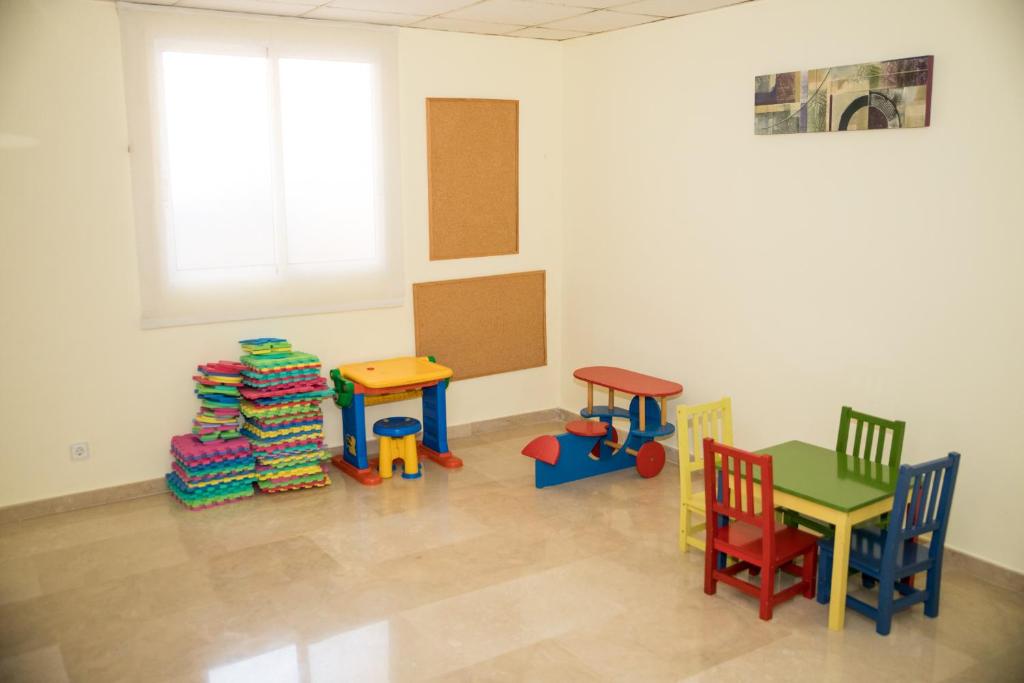 a room with colorful chairs and tables and a window at Hotel Porto Calpe in Calpe