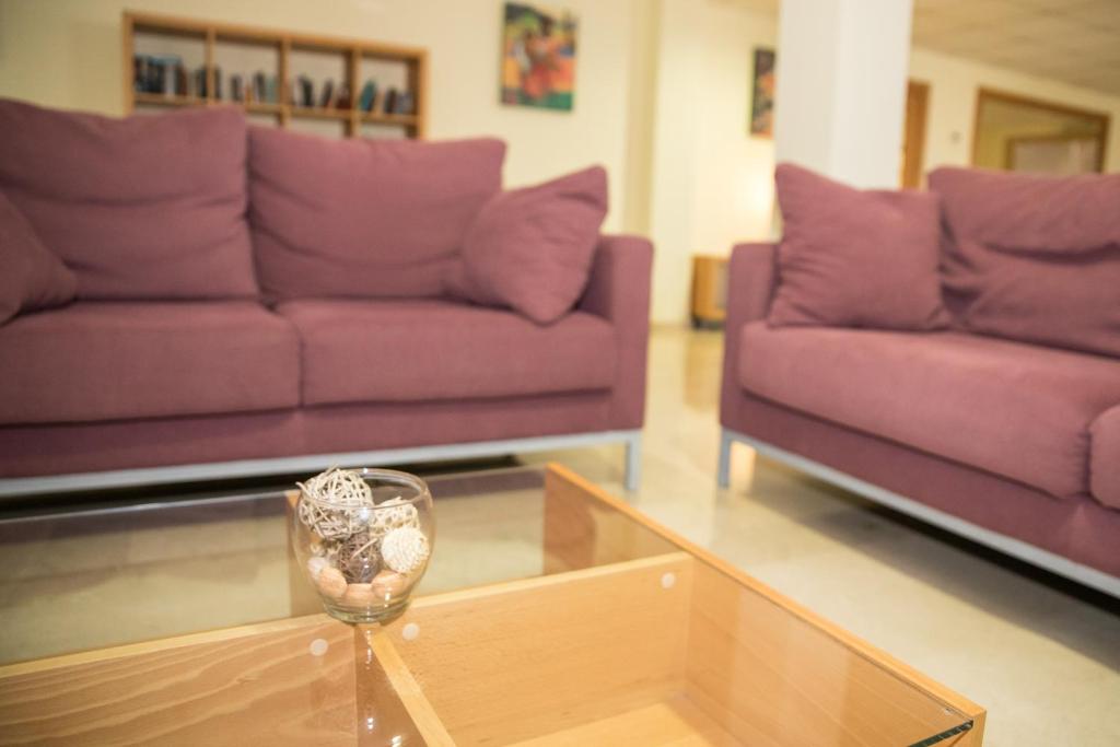 a living room with purple couches and a glass coffee table at Hotel Porto Calpe in Calpe