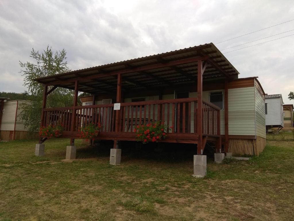 a house with a deck with flowers on it at Mobilheim Vyhlídka Camp Výrovice in Výrovice