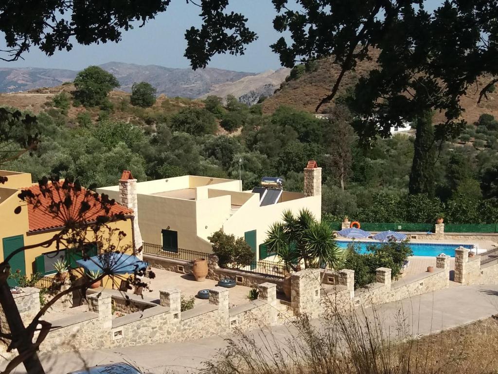 un complejo con piscina y montañas de fondo en Metochi Villas, en Spílion