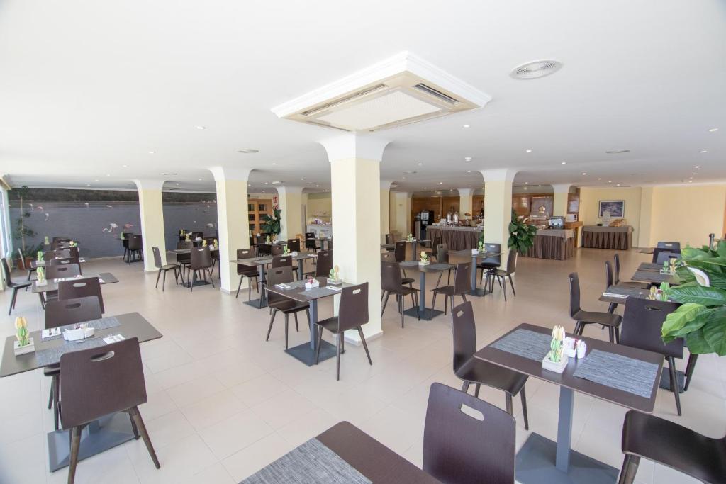 a restaurant with tables and chairs in a room at Hotel Porto Calpe in Calpe