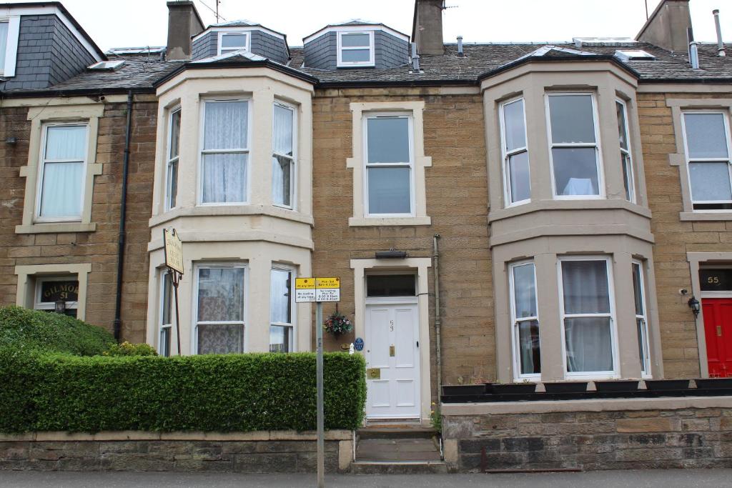 een groot bakstenen huis met een rode deur bij Cruachan Guest House in Edinburgh