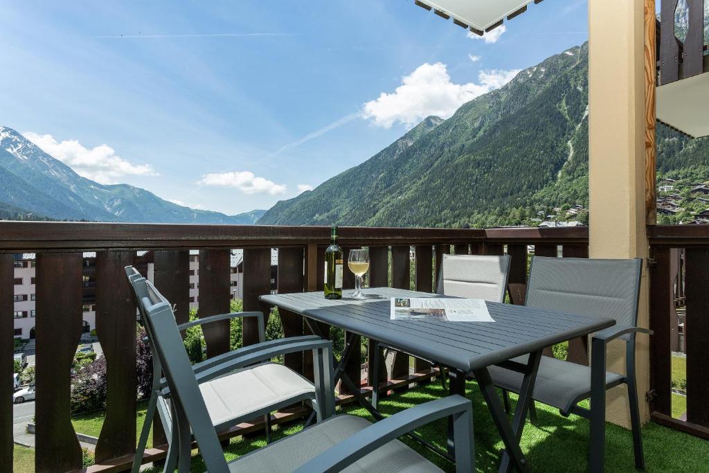 d'une table et de chaises sur un balcon avec vue sur les montagnes. dans l'établissement Apartment Aiglons - Central Chamonix Mountain Haven, à Chamonix-Mont-Blanc